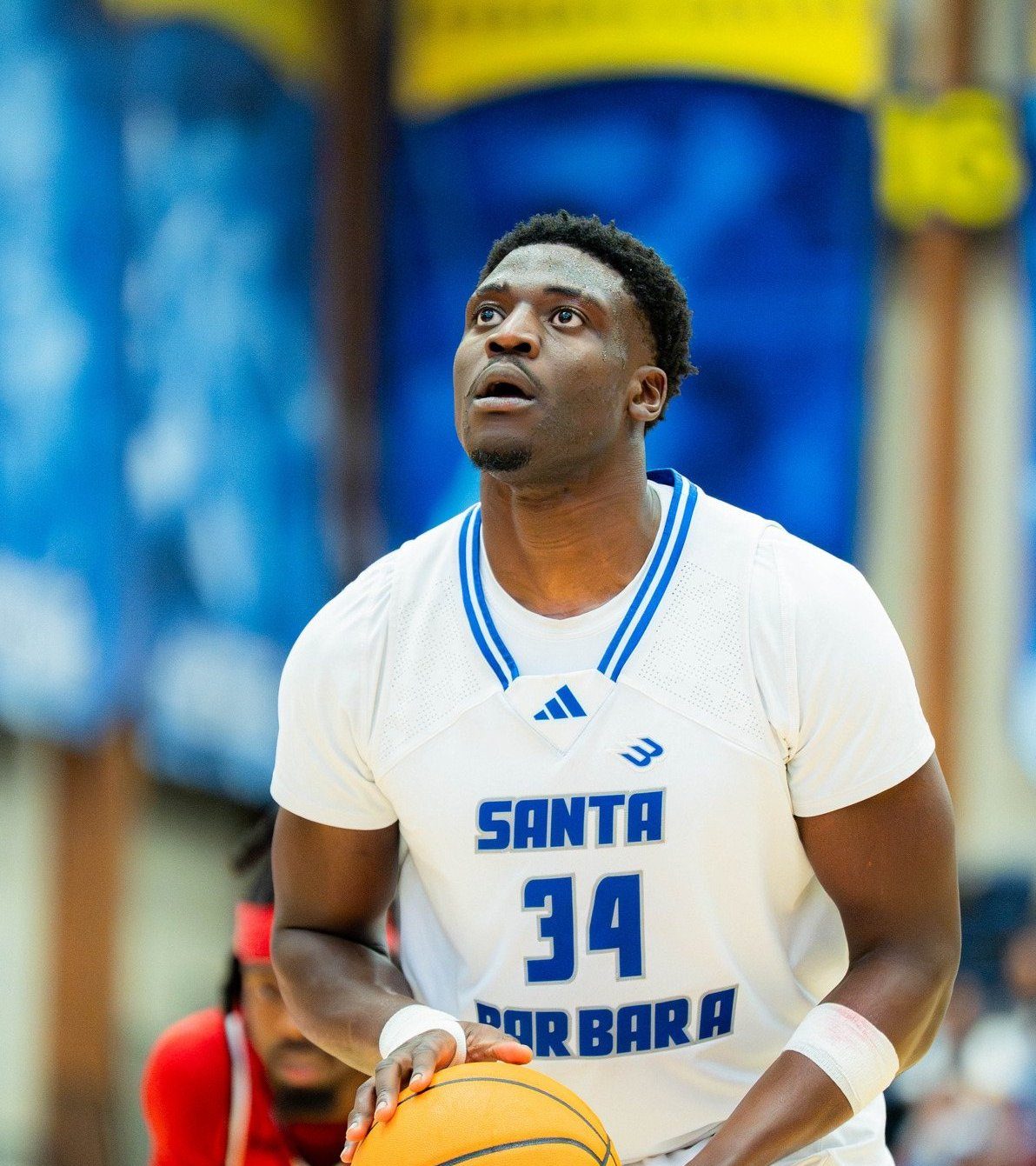 Hosana Kitenge in a UCSB #34 jersey, holding the ball and looking up